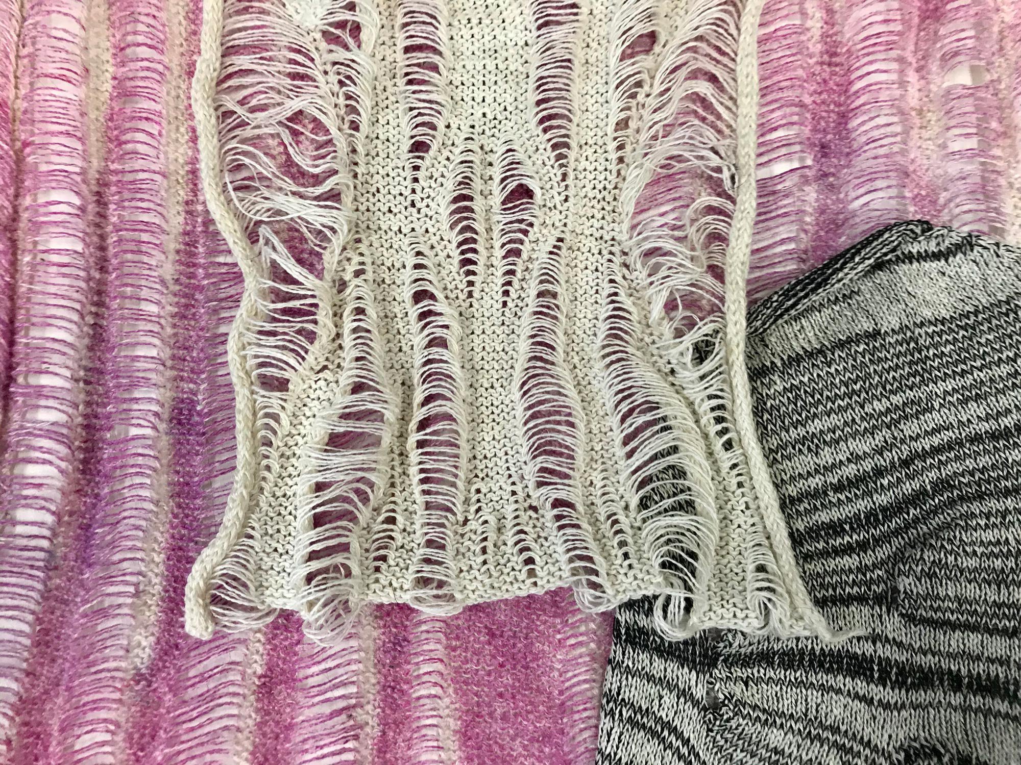 Samples of knitwear, pink, off whites and greys